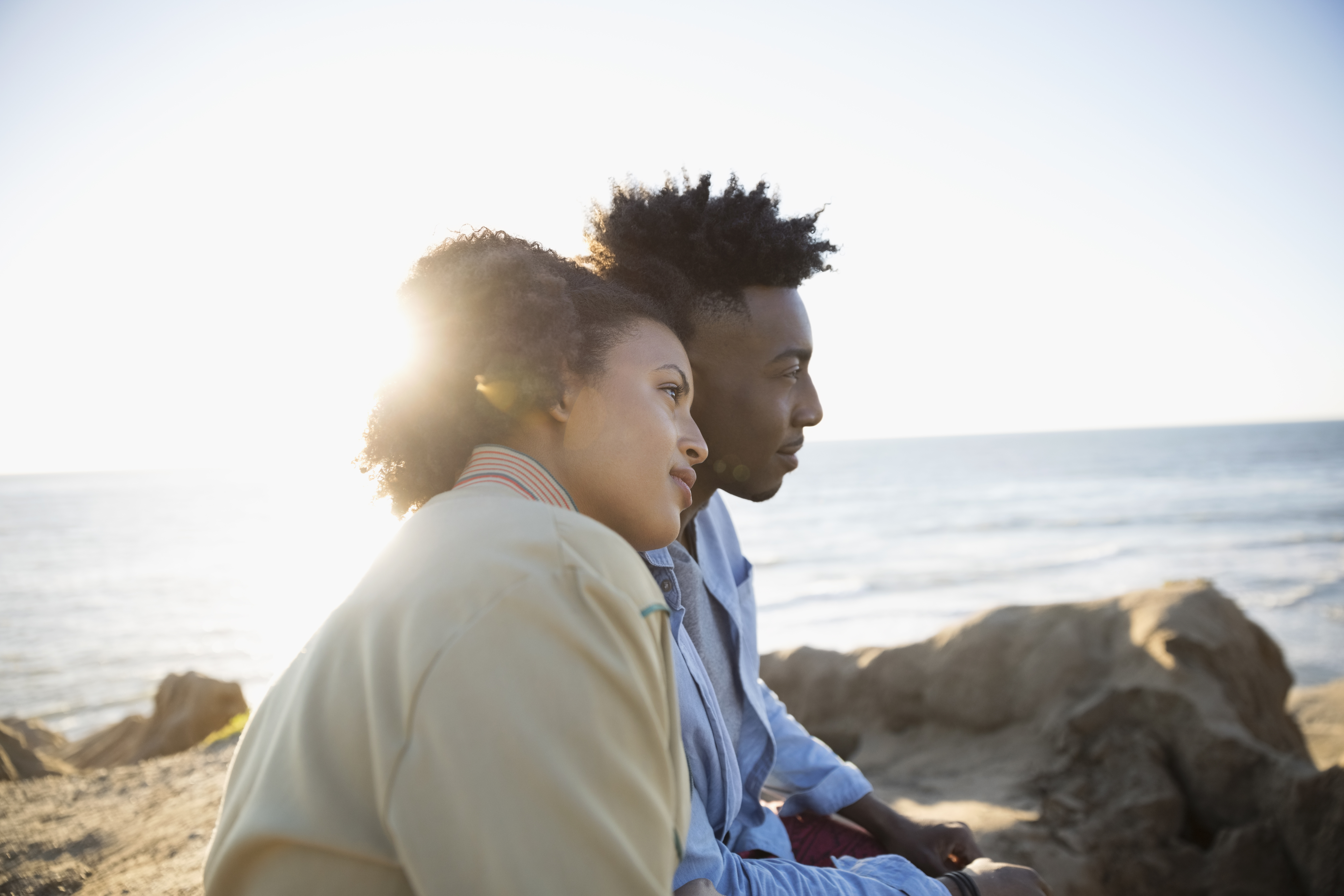 Affectionate young couple looking at sunny ocean view