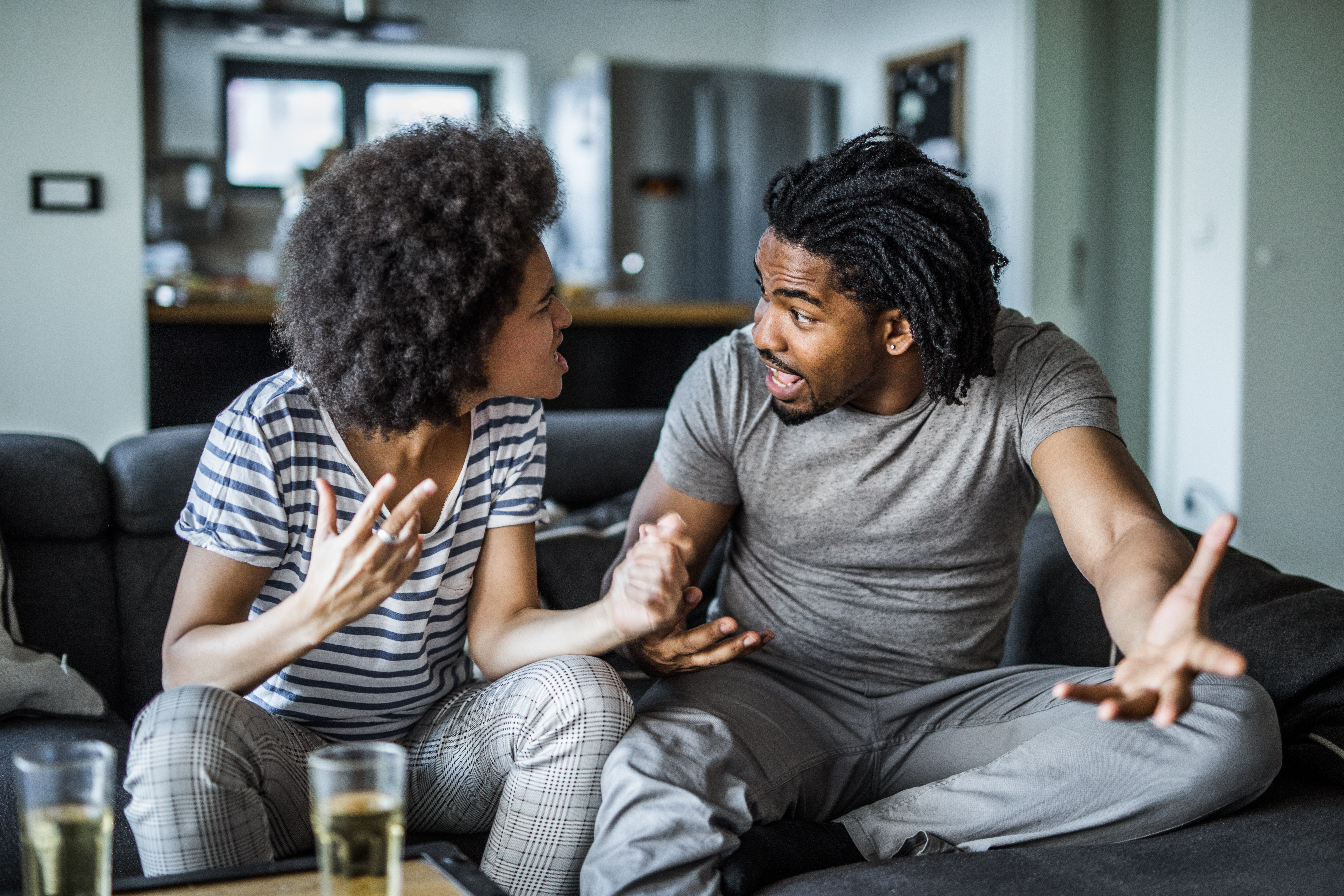 Angry African American couple arguing in the living room.