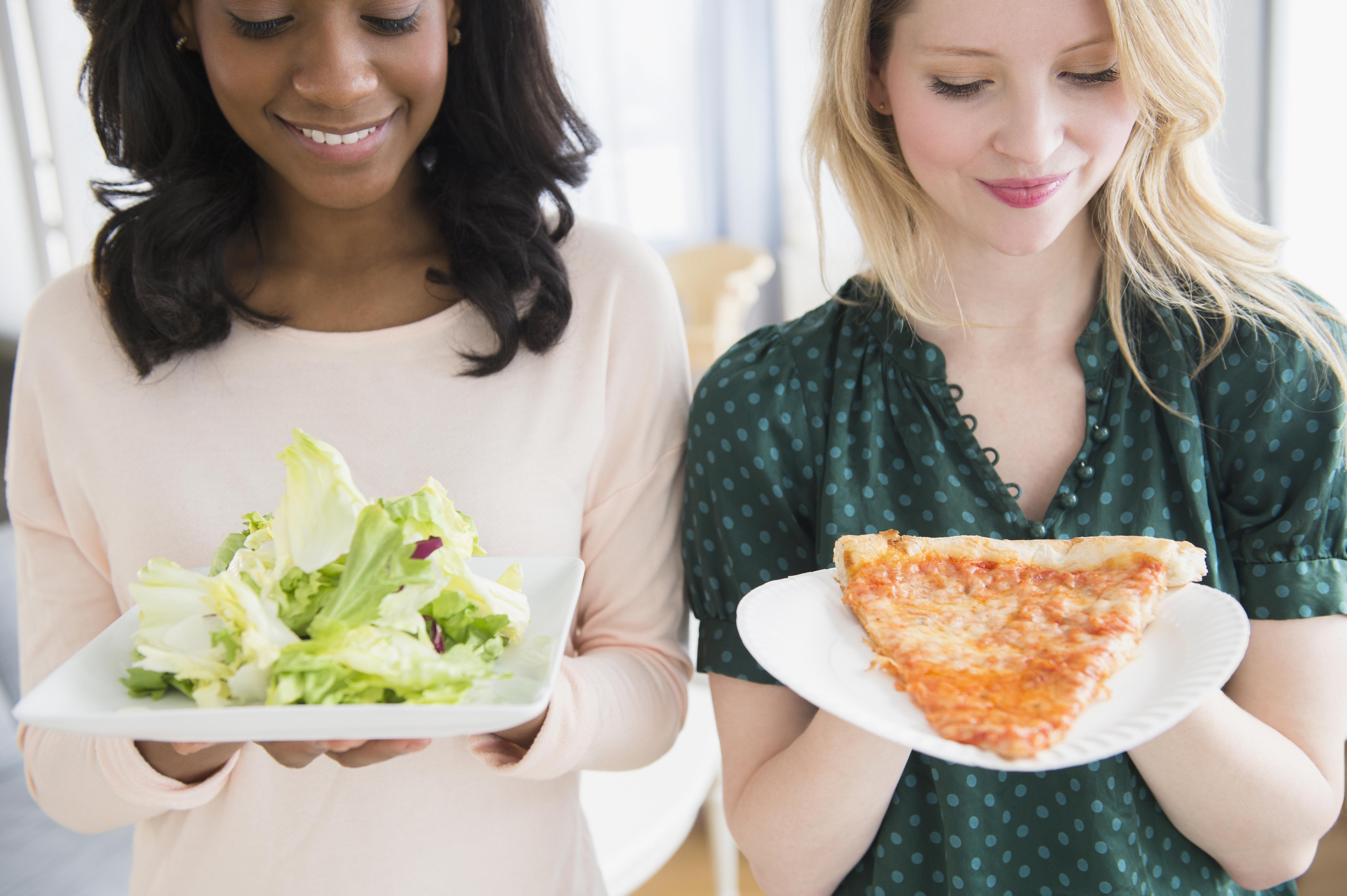 Women eating pizza and salad