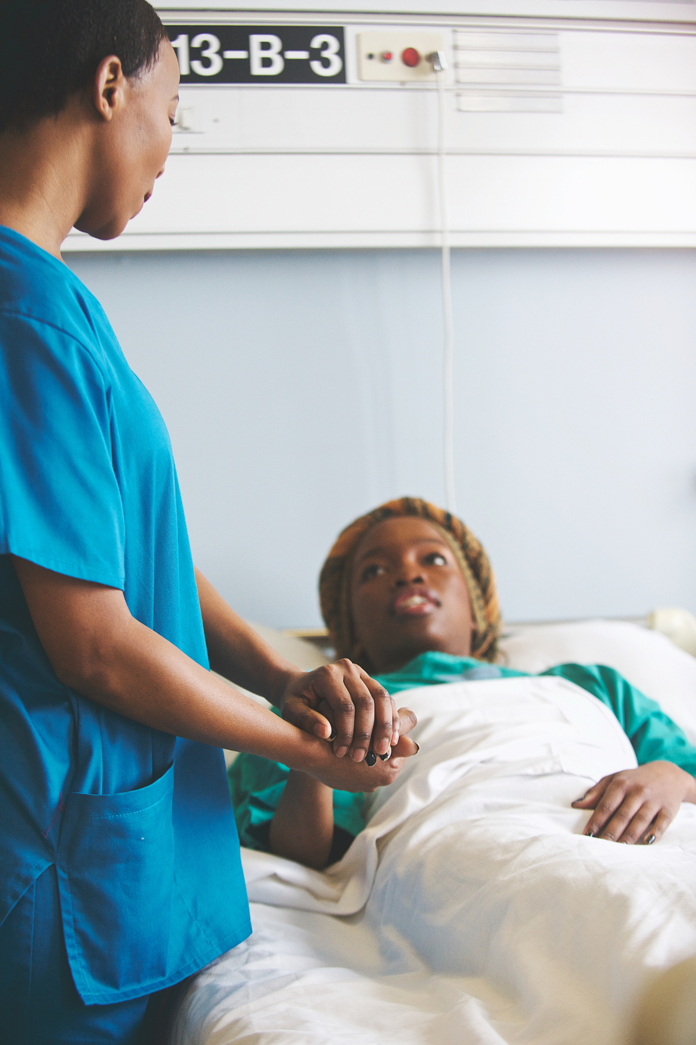 Female doctor in medical scrubs attending to a patient in hospital closer