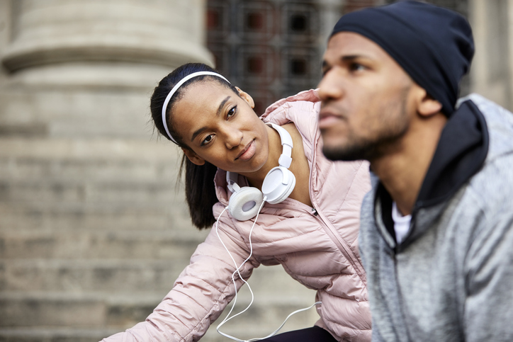 Young woman exercising while looking at man