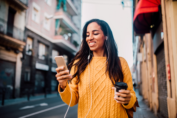 Woman with headphones using phone