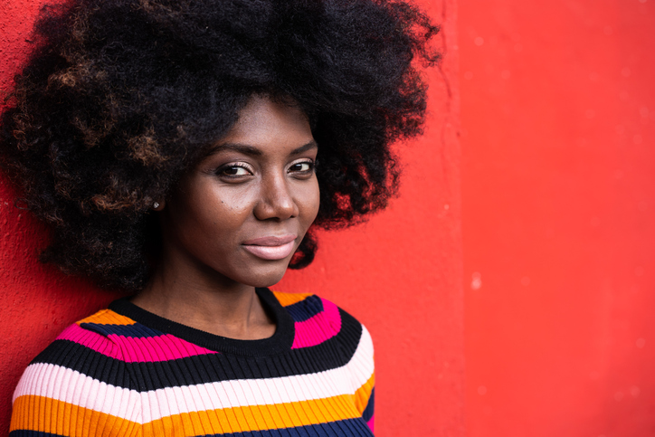 Portrait of a smiling afro woman on colorful background