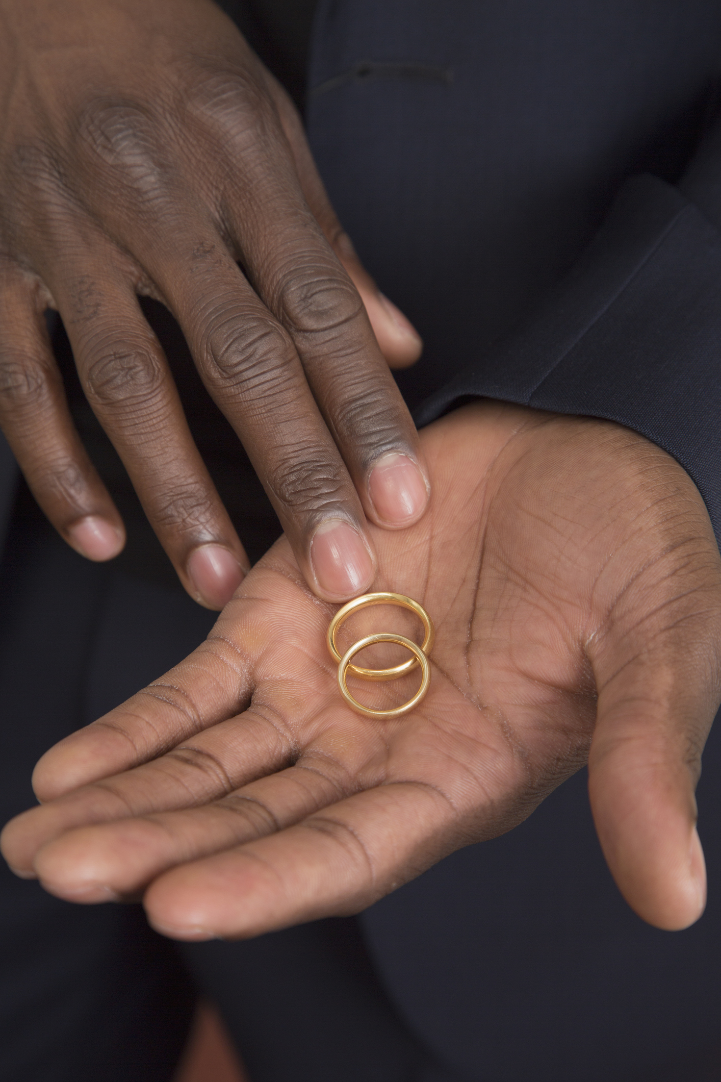 Midsection of man holding wedding rings