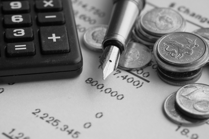 top view of coins, pen calculator and accounting document