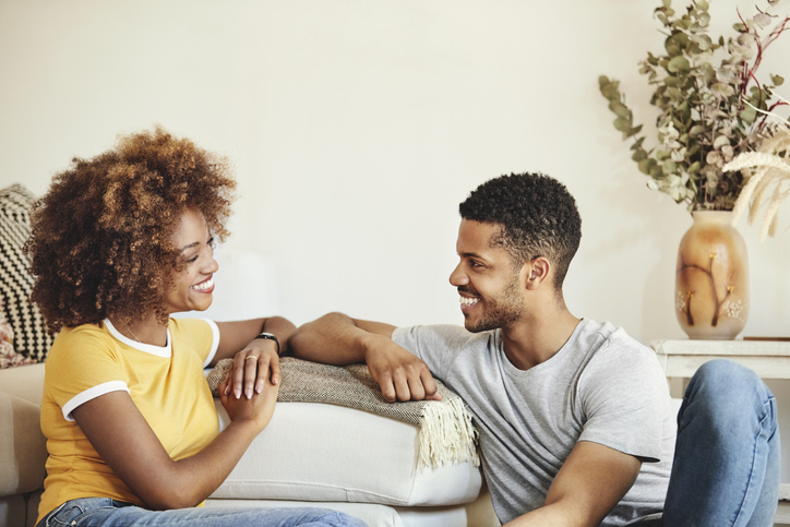 Cheerful couple looking at each other in room