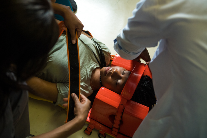 Healthcare workers strapping unconscious patient