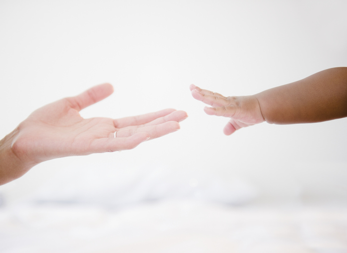 African American woman reaching out to baby boy