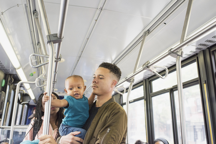 Young mother father and infant riding city bus