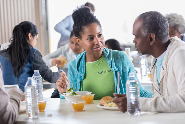 Confident soup kitchen volunteer enjoys a meal