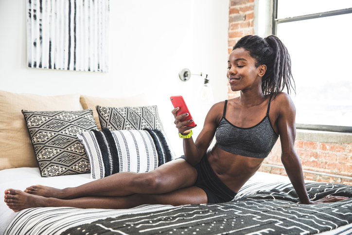 Afro american woman chilling out on the bed after work out