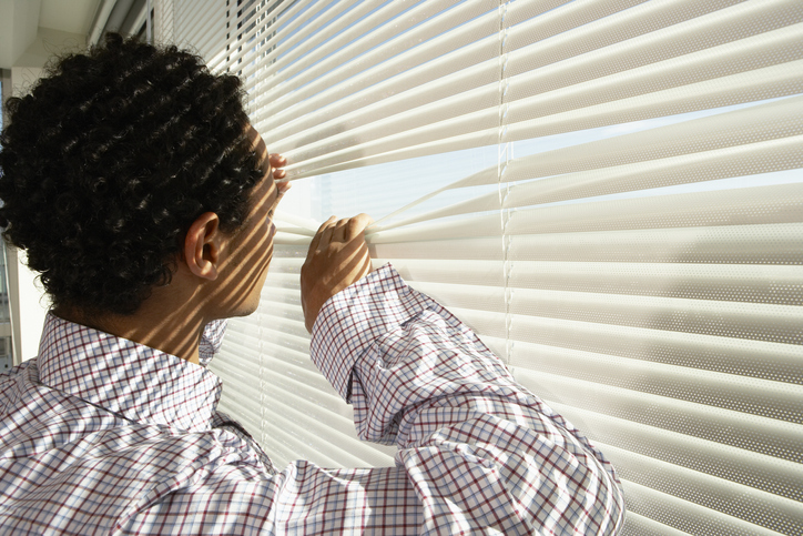 Businessman Peeking out Window