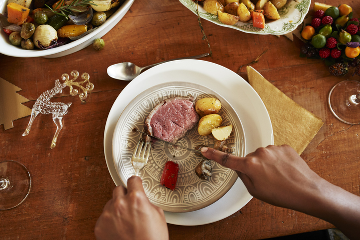 Cropped hands of woman eating meal on dining table