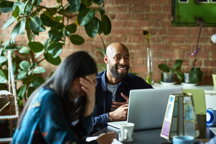 Cheerful African American businessman in meeting with female colleague