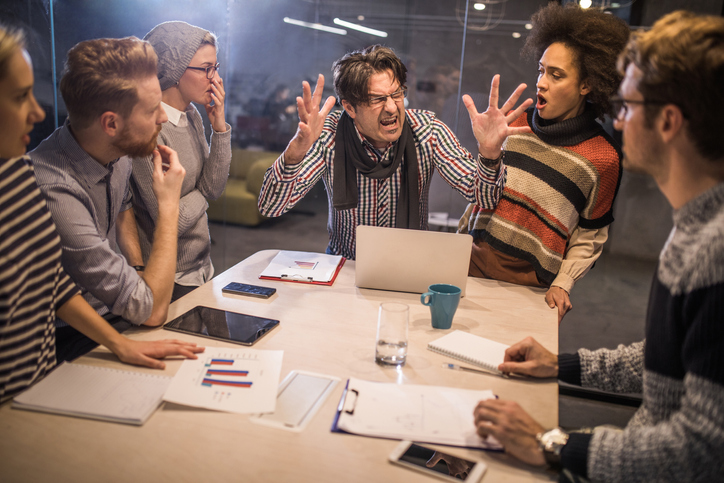 Furious boss shouting at his team on a meeting in the office.