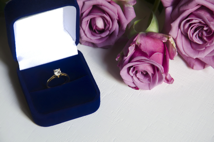 Engagement ring in a box and pink roses