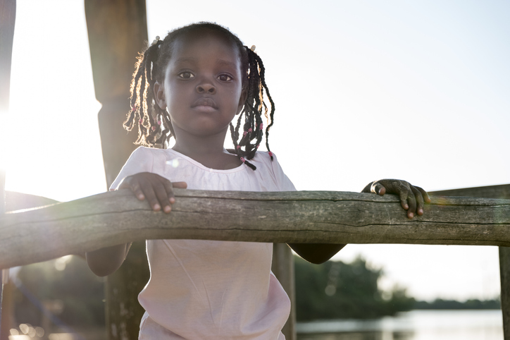 children portrait: cute girl at playground, looking at camera