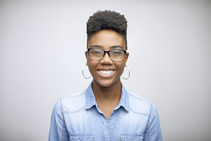 Smiling female afro owner against white background
