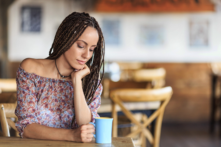 Beautiful woman drinking coffee alone