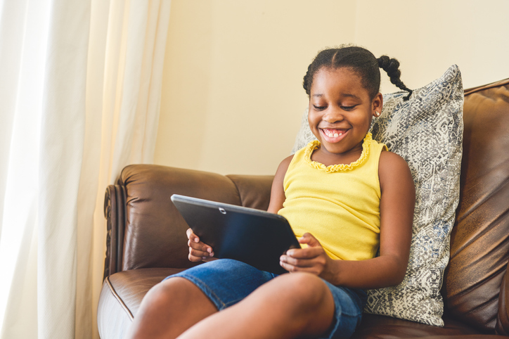 dark-skinned african-american girl watching tablet