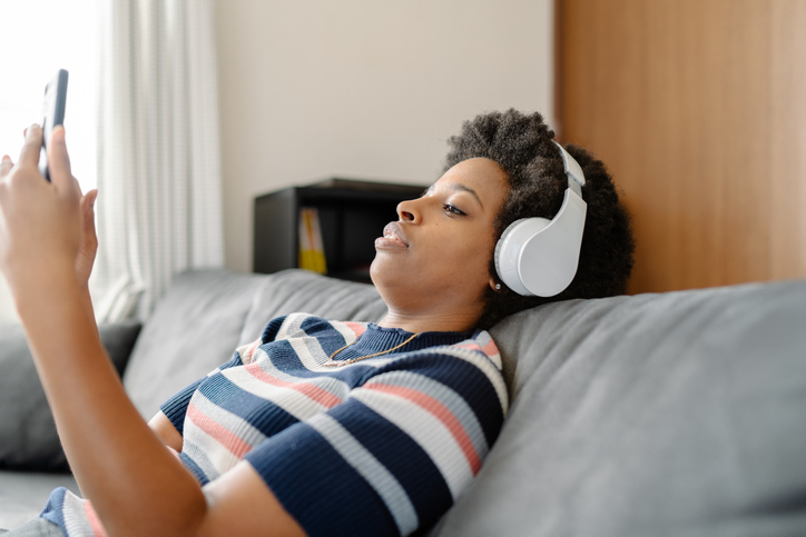 Young woman listening to music while sitting on sofa
