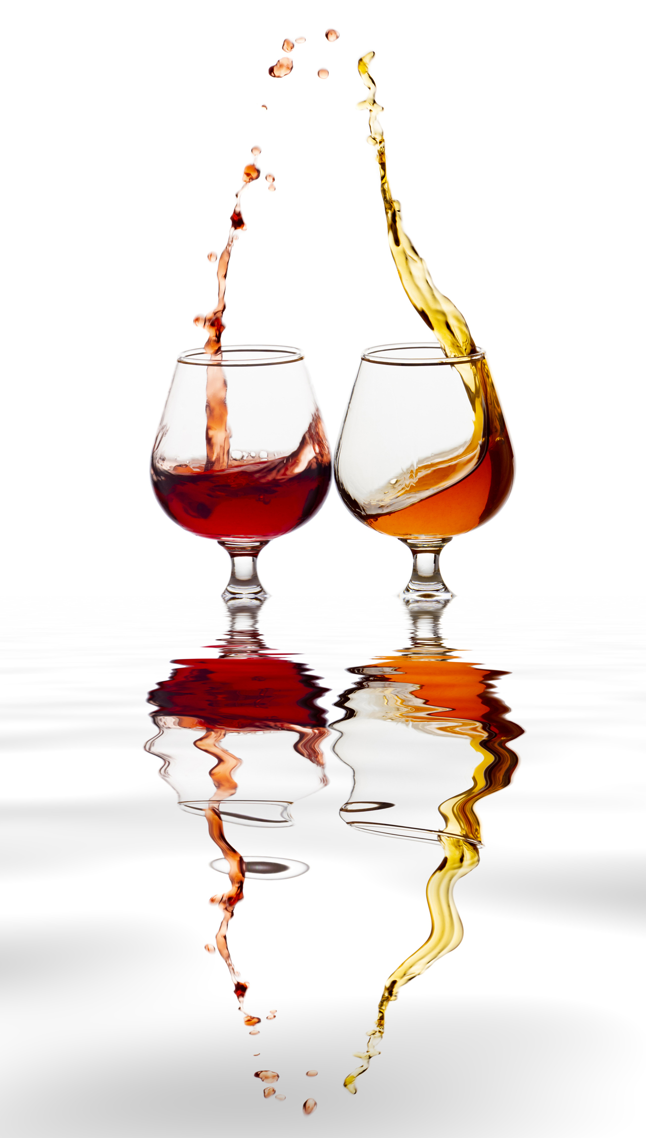 Raising a toast of liquor glasses on a white background reflected on a water surface.