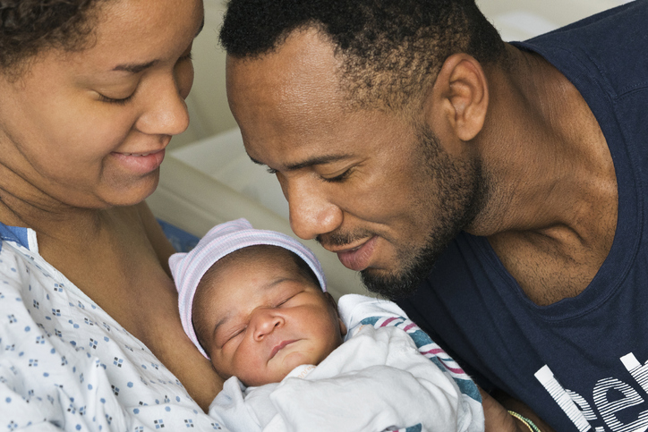 Black parents admiring newborn son in hospital