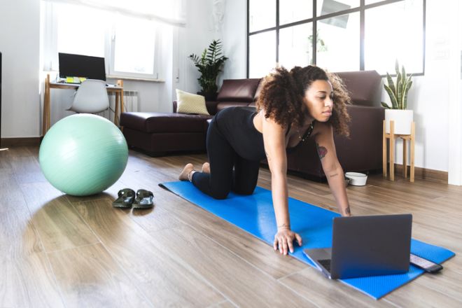 Pregnant woman practicing Yoga with online video class