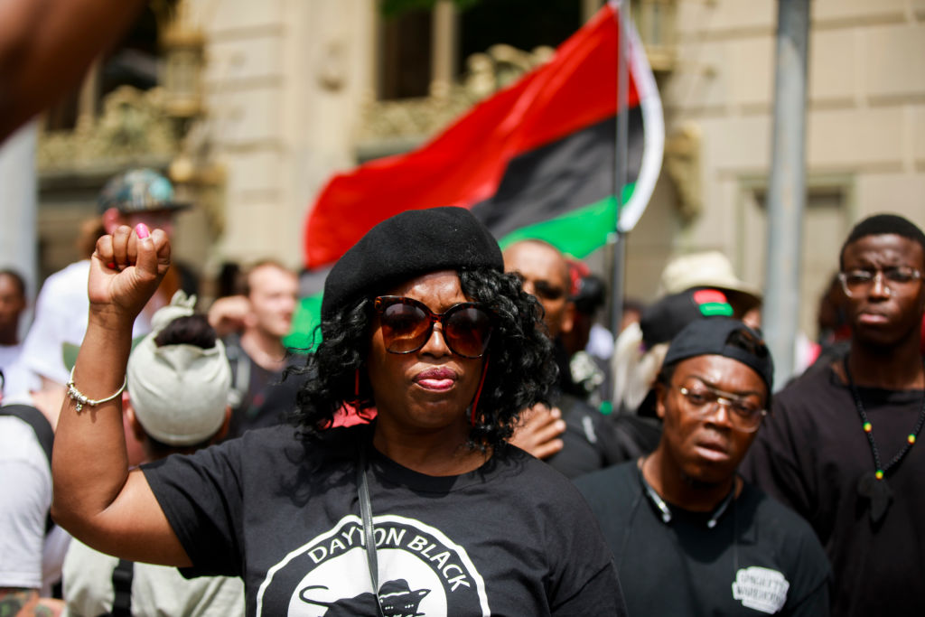 A member of the New Black Panthers makes a Black Power fist...