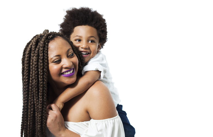 Black beautiful son hugging mom from behind both smiling