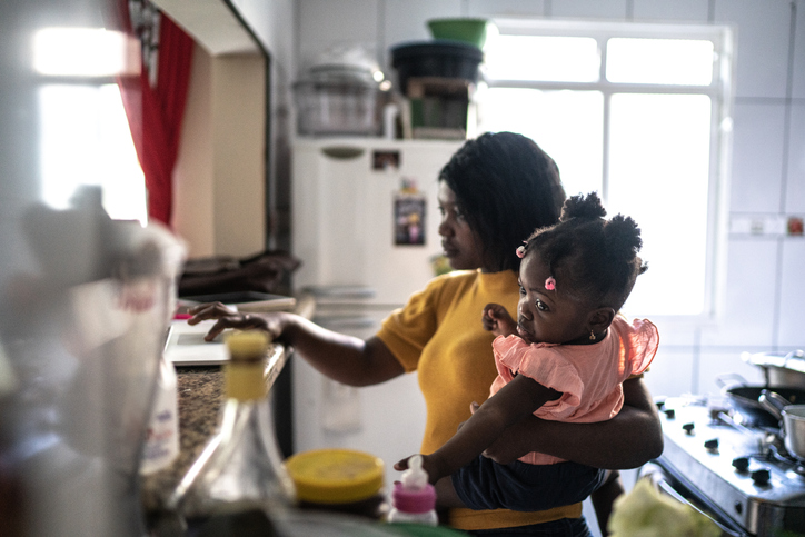 Mother doing homeoffice while holding her baby girl