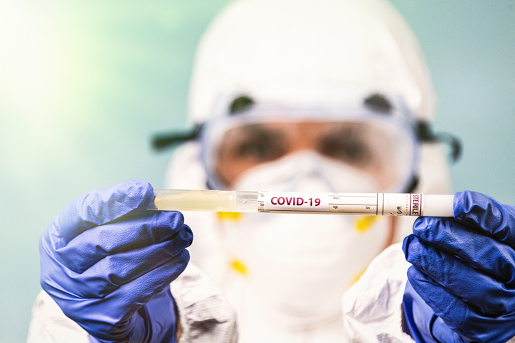 Healthcare worker holding a container of Covid-19 test sample