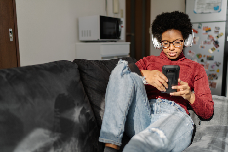 Woman laying on sofa and listening to music
