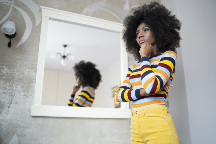 Woman looking at her reflection in the mirror