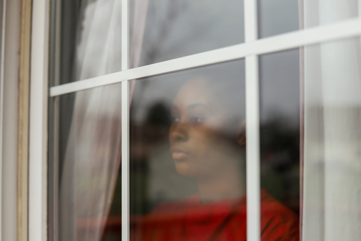 Portrait Of Young Woman Seen Through Glass Window