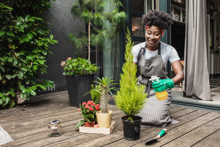 Young woman enjoys taking care of plants in the garden