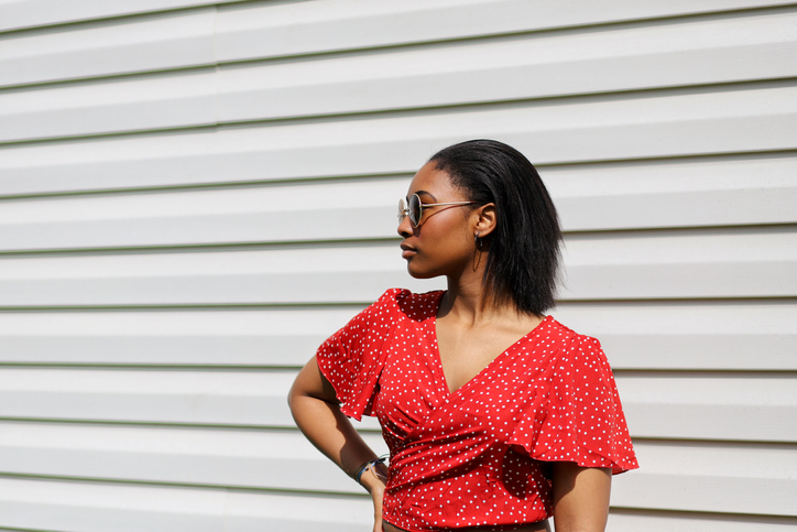 Beautiful Young Woman Looking Away Against Wall