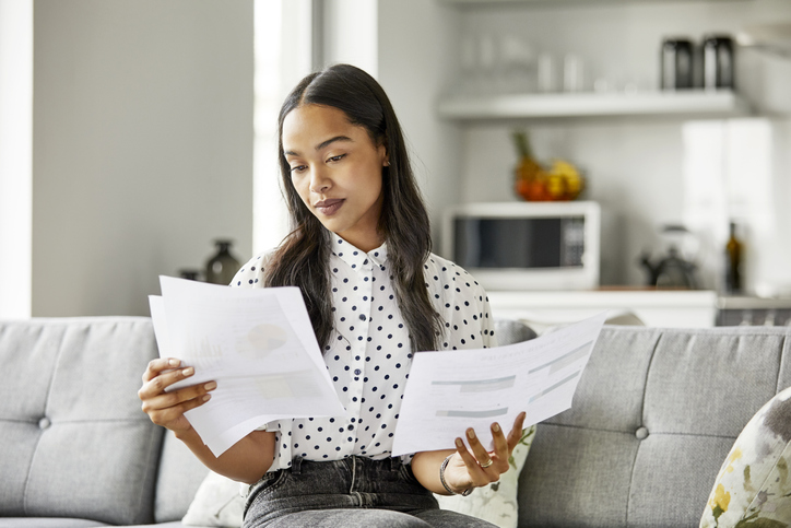 Woman analyzing financial documents at home