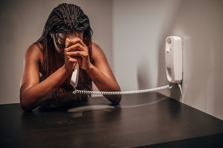 Sad female visitor in prison visit room