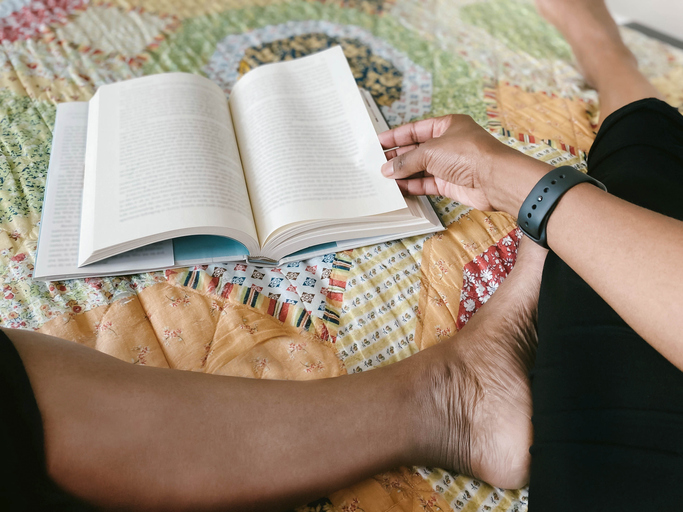 Woman Reads Book in Bed