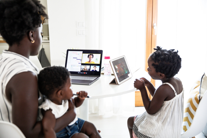 Business woman working at home and taking care of her two daughters