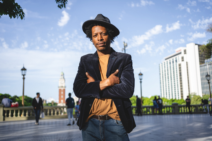 Cool well dressed black man standing in a plaza