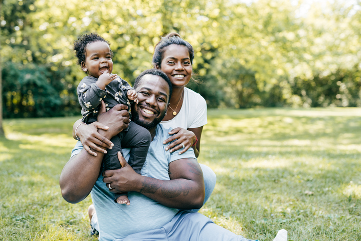 Laughing family with baby daughter in the park