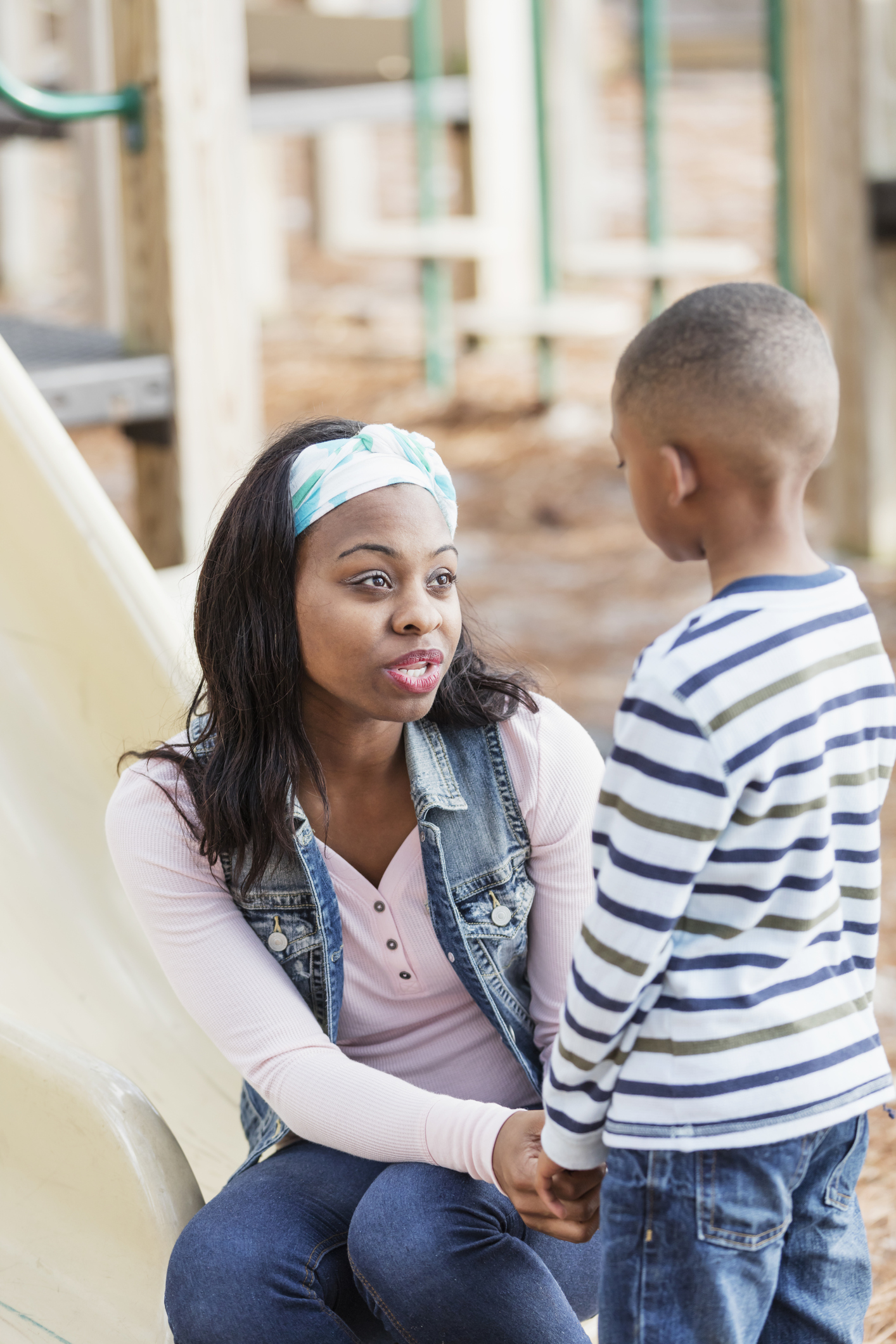 Mother talking to little boy on playground