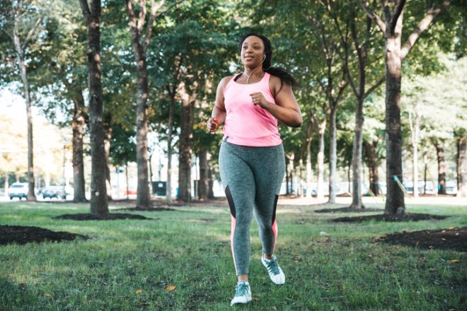 Healthy woman jogging listening to music at the public park