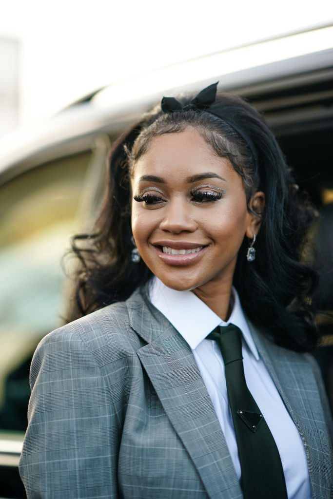 Saweetie in a suit smiling