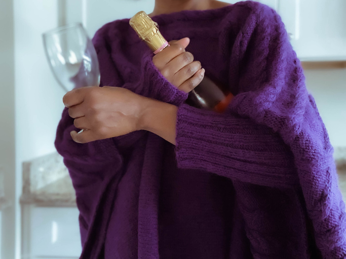 Woman Holds Bottle of Wine and Glass