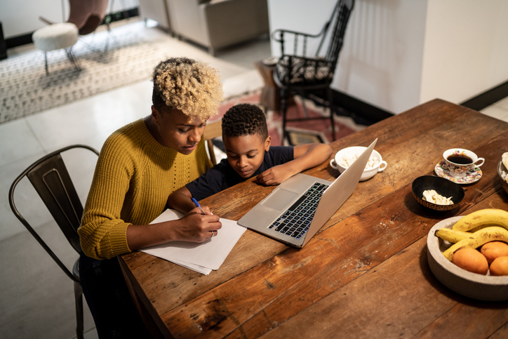 Mother helping son with home work at home