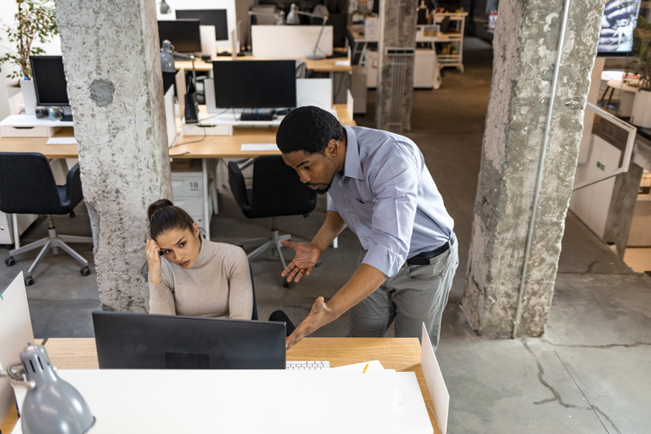 Doubtful African hr talking to Caucasian applicant at job interview