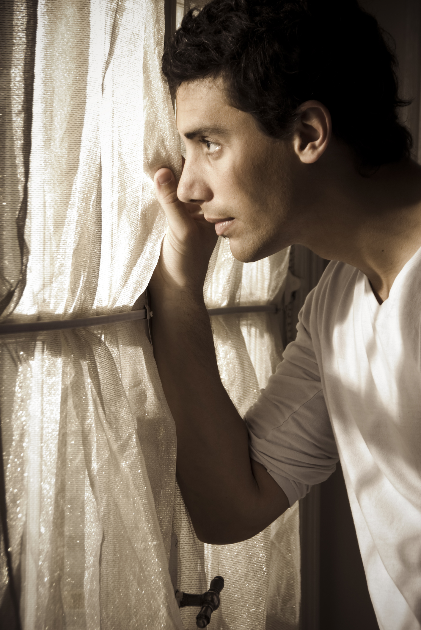 Argentina, Buenos Aires, Profile of young man looking trough window